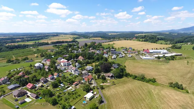 Vlastibořice shora, vpravo zemědělský areál s bílými halami a pole