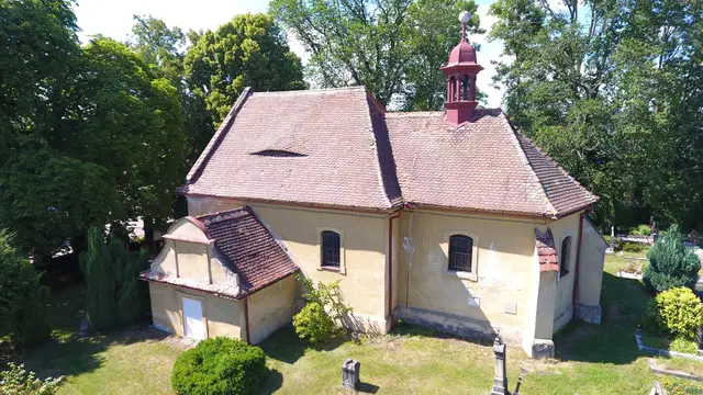 Kostel sv. Kateřiny se žlutou omítkou a vížkou na hřbitově
