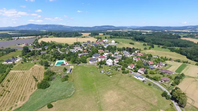 Vlastibořice s vodní nádrží, v popředí pole a louka