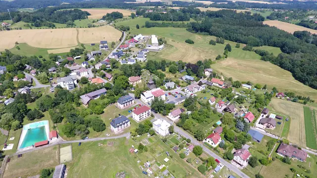 Vlastibořice shora: vodní nádrž vlevo dole a domy podél silnice